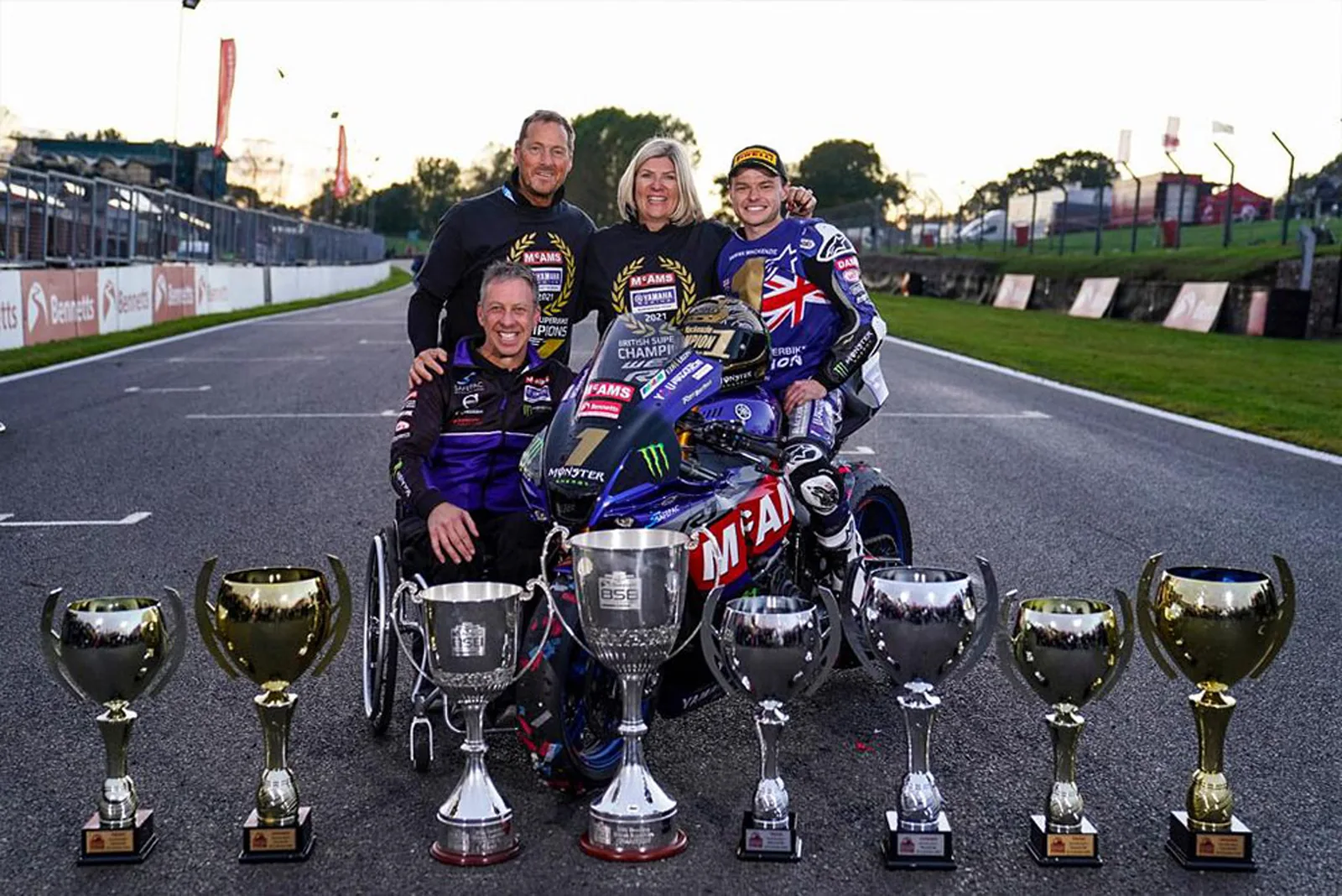 James and family on a championship race grid with the motorcycle and trophies